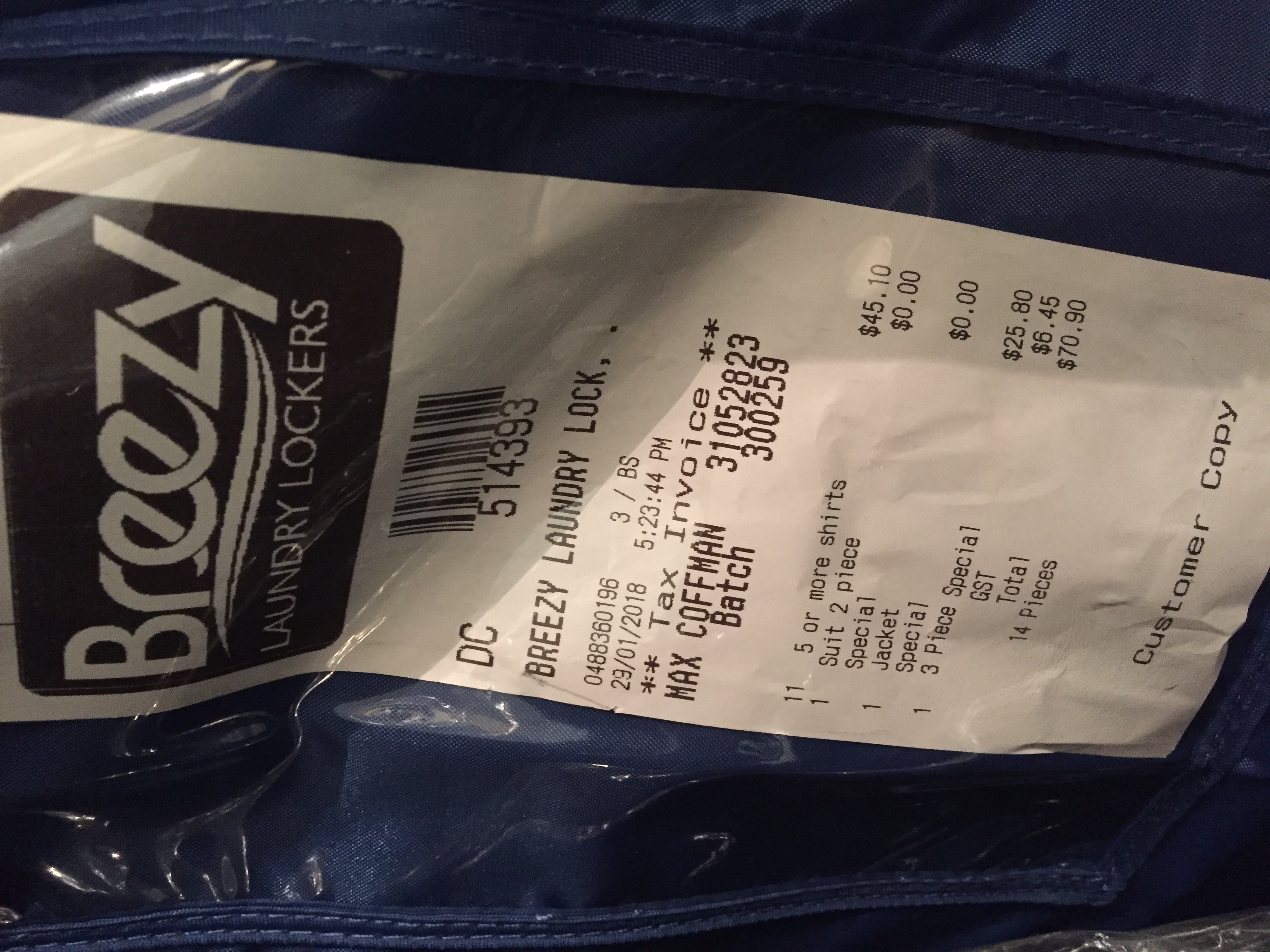 A real customer's tax invoice tag attached to a garment bag: eleven shirts, a two-piece suit, a jacket, and a 3-piece special, totalling $70.90