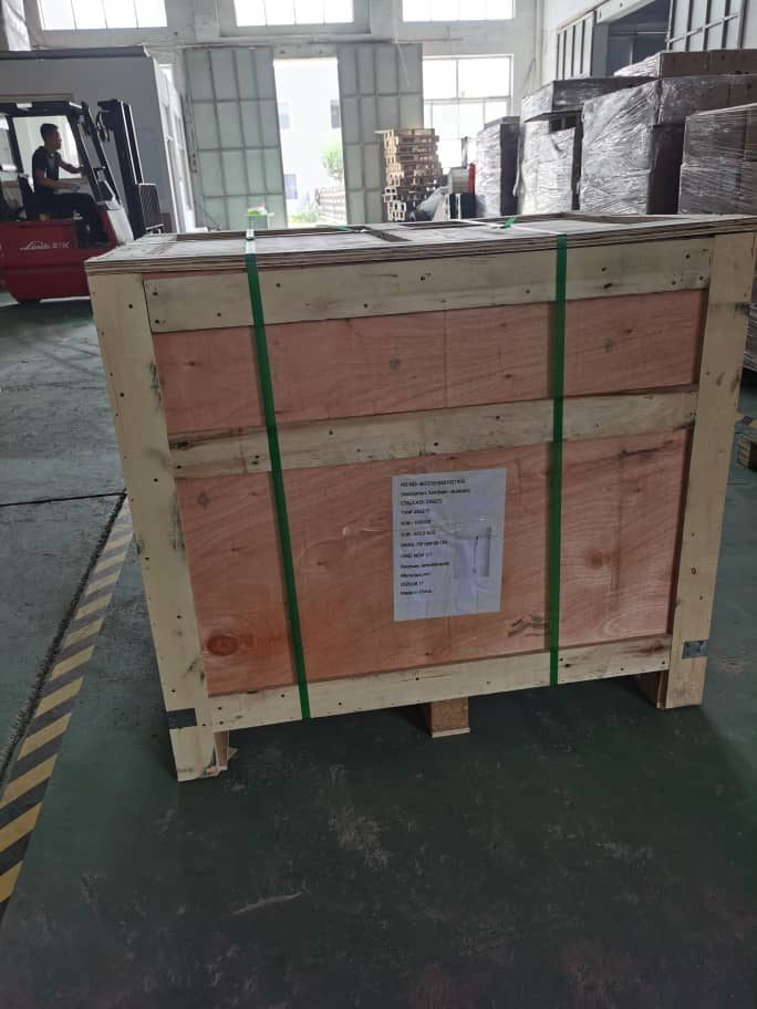 New purpose-built plywood shipping crate for a locker order, banded with green strapping on the factory floor before international export